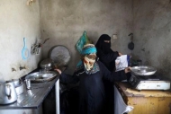  أم هاني الشرعبي تشير إلى أطباق فارغة في مطبخها بصنعاء- رويترز